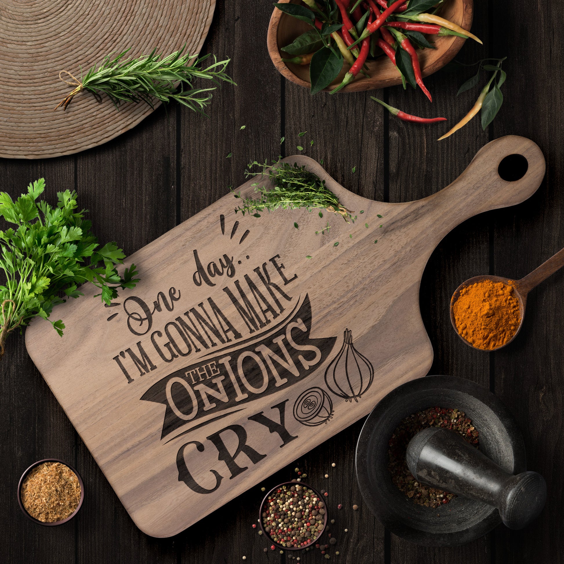 view of walnut cutting board with the words "one day i'm gonna make the onions cry" on a brown table with herbs and spices as decoration