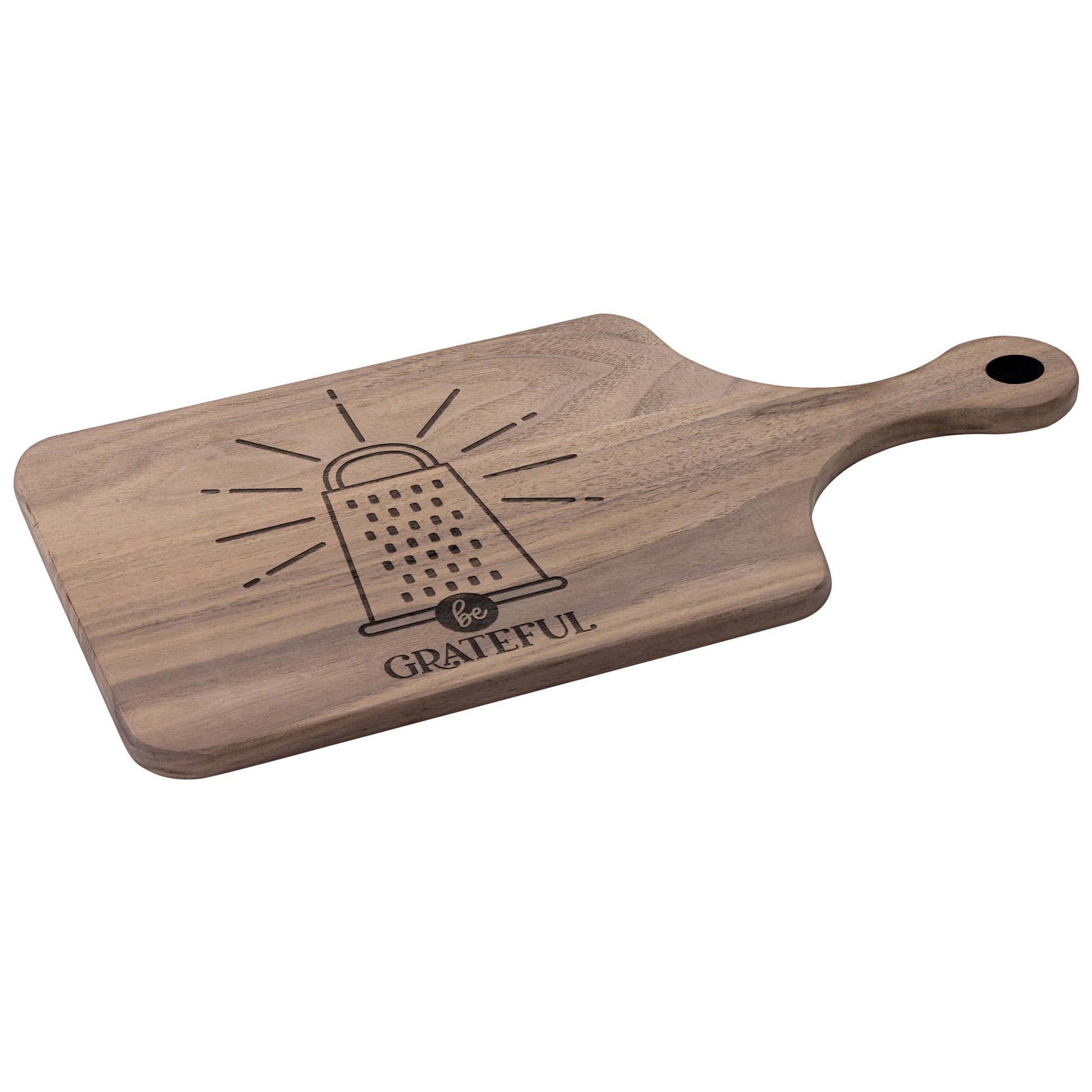 a walnut cutting board with a cheese grater with the words "be grateful" engraved on the cutting board on a white background